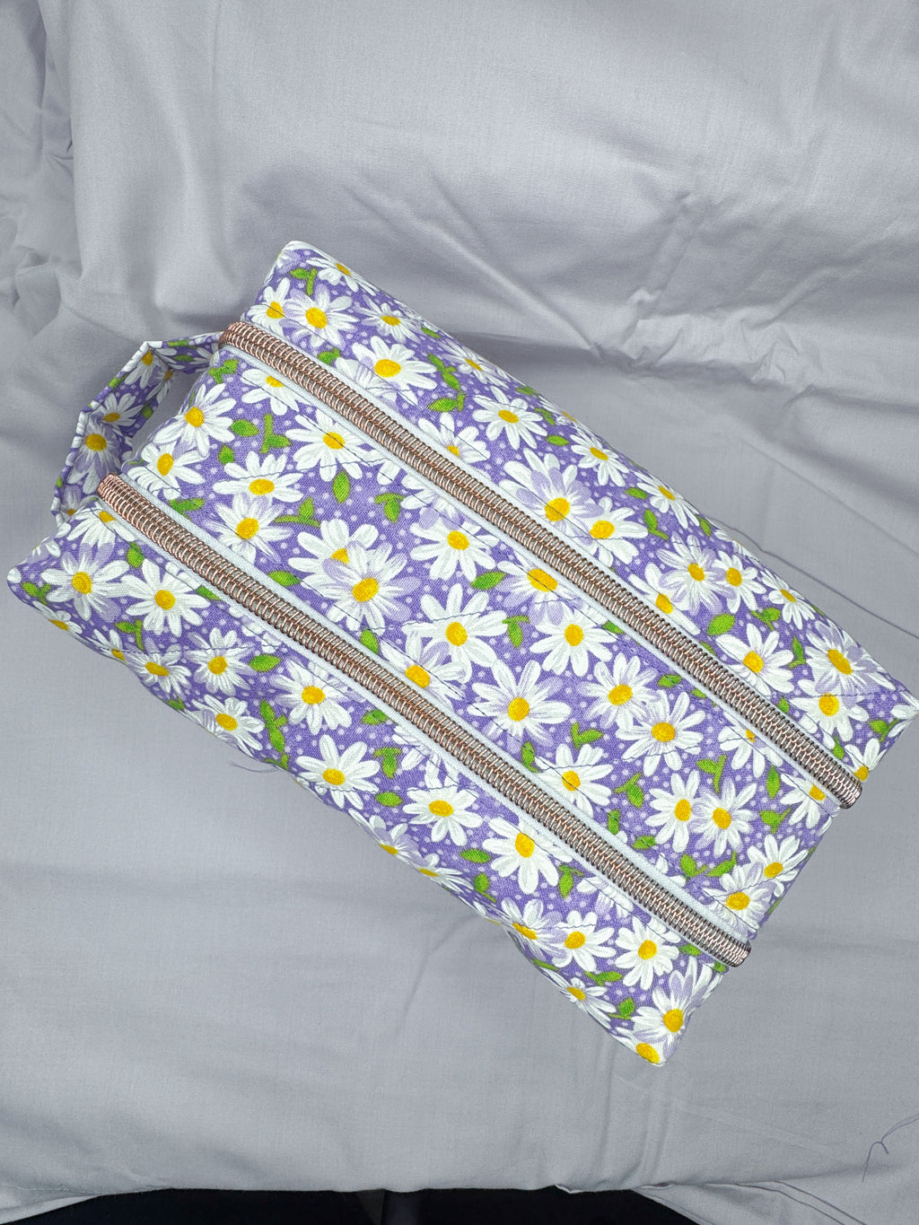 Floral-patterned pouch with zippers on a gray background