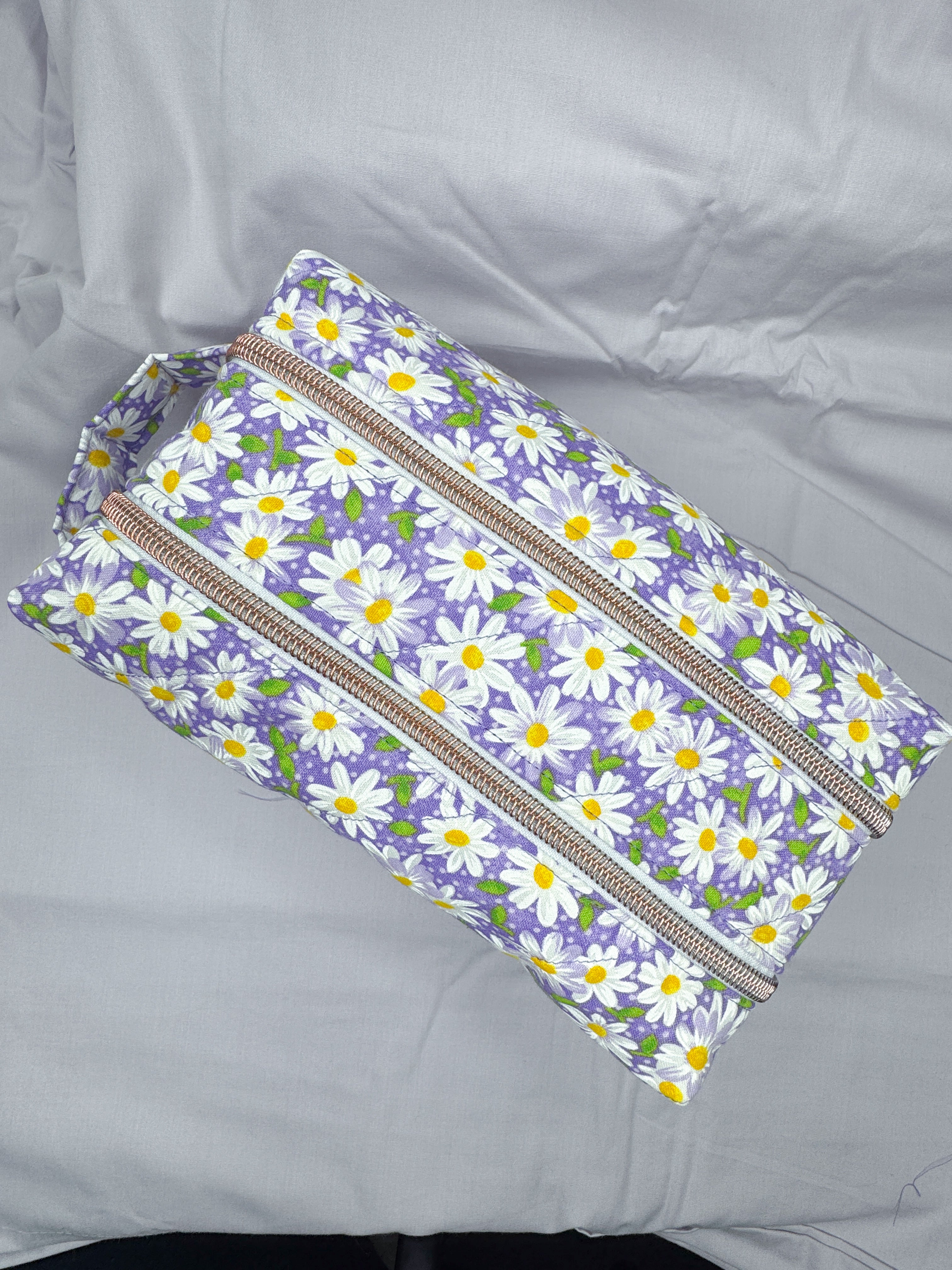 Floral-patterned pouch with zippers on a gray background
